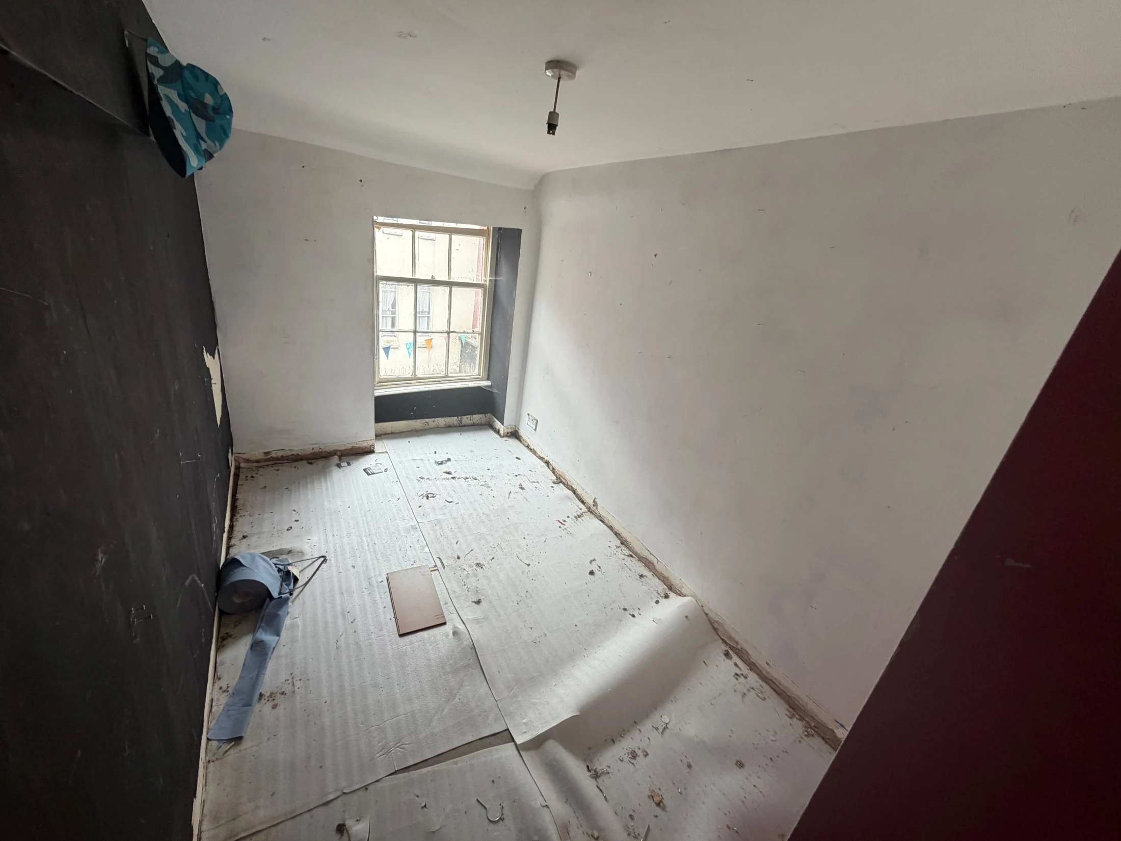 A vacant upstairs room with a sash window
