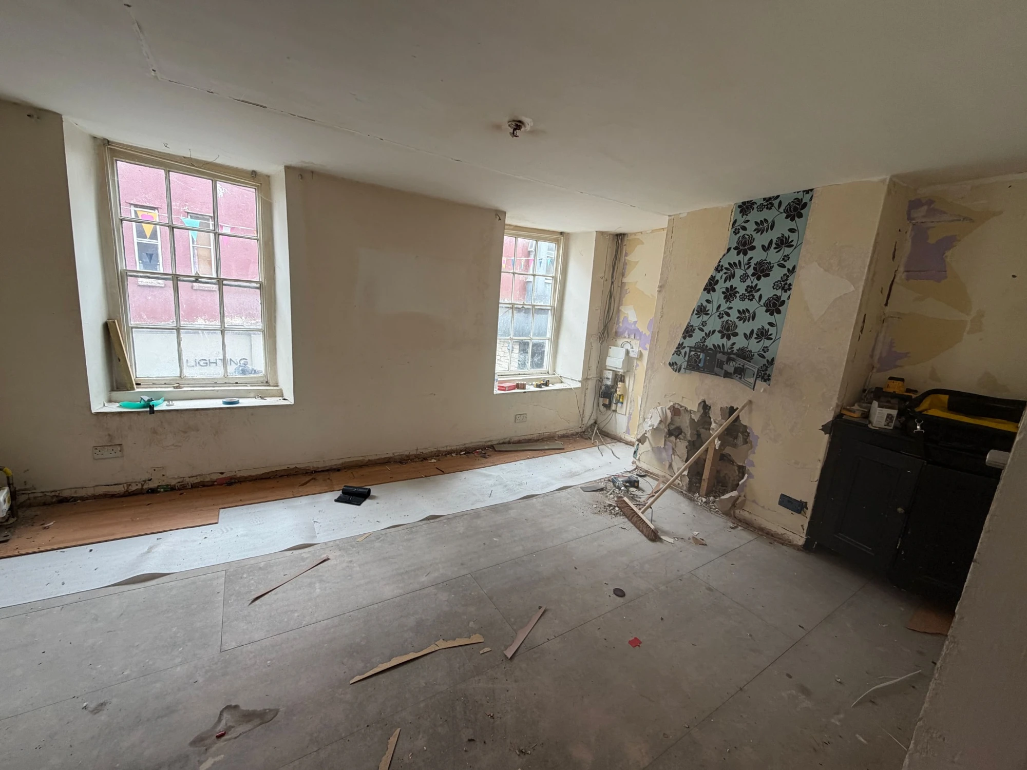 The living room before refurbishment, with exposed flooring and its existing windows