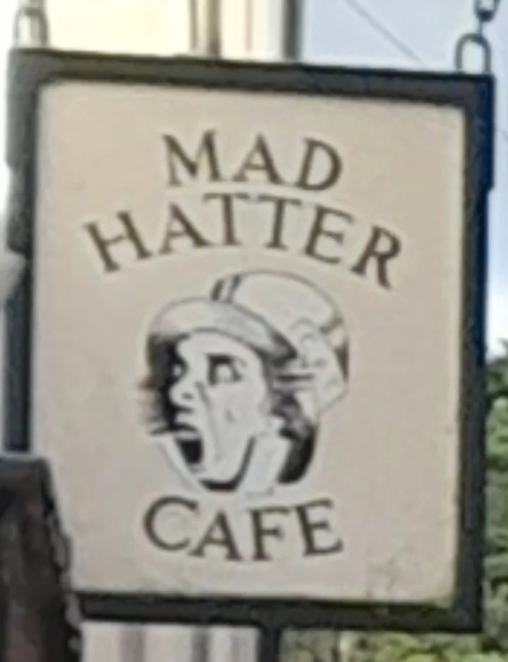 The illustrated Mad Hatter Café hanging sign